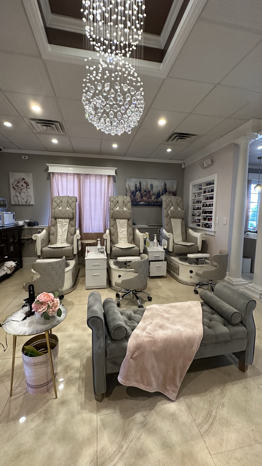 Dolce's pedicure room with crystal chandelier and white tufted thrones
