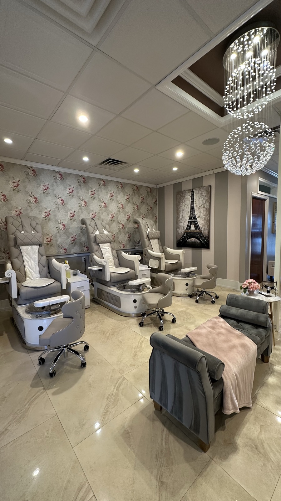 Pedicure room at Dolce's Nails & Spa — three white tufted thrones beneath a crystal chandelier